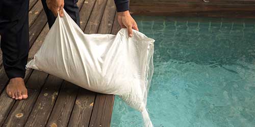 A man pouring salt into a salt water system