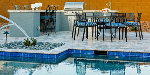 An outdoor kitchen setting next to one of our pools