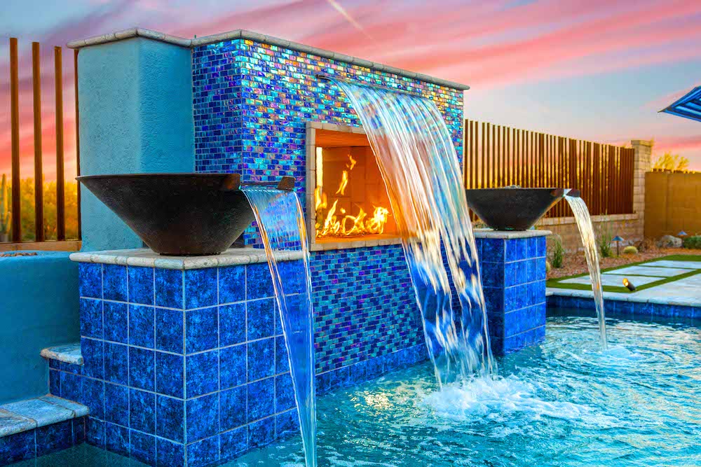 A pool fire pit wall with a rain curtain flowing over it