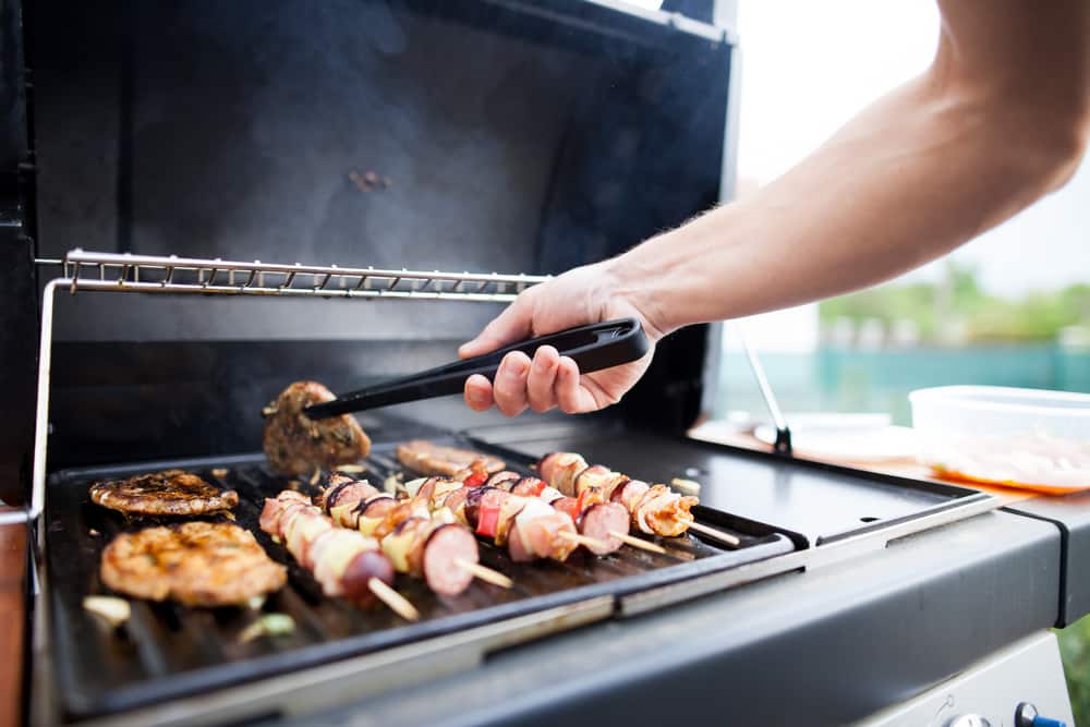 Man Using Outdoor BBQ Island For Grilling