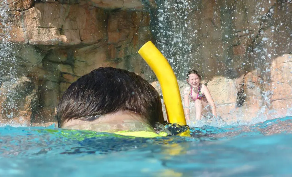 Small Girl in Pool Grotto Seeing Boy Swimming
