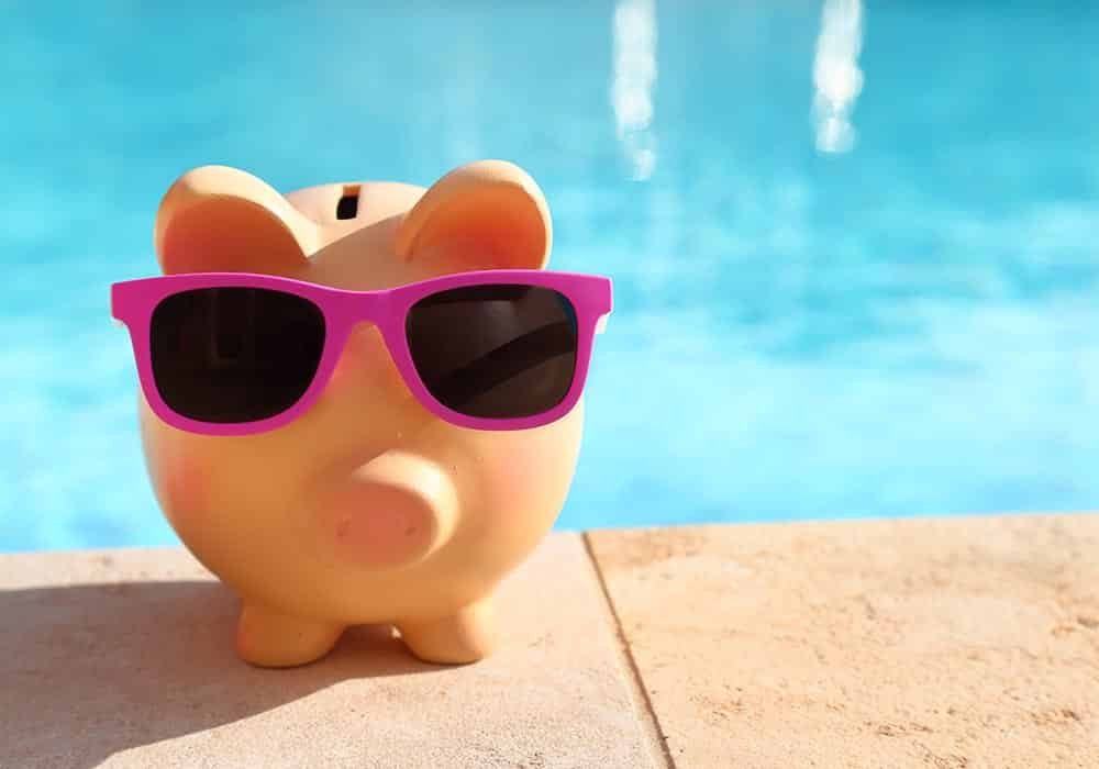 a piggy bank with pink sunglass near pools by design salt water pool