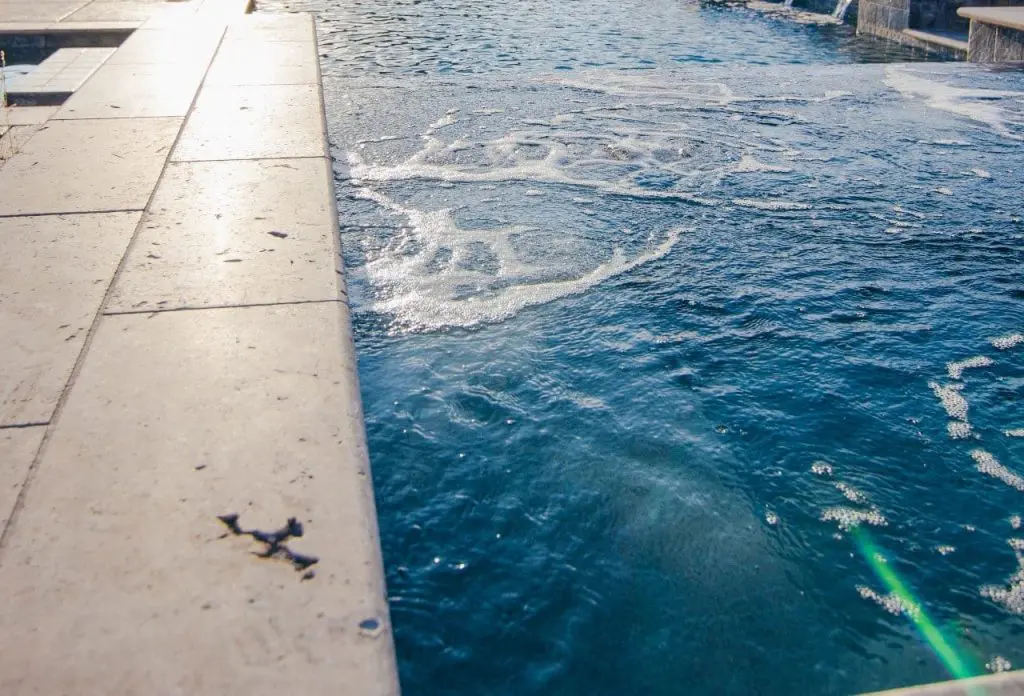 pools by design using travertine pavers around the pool