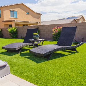 A poolside seating area with artificial grass