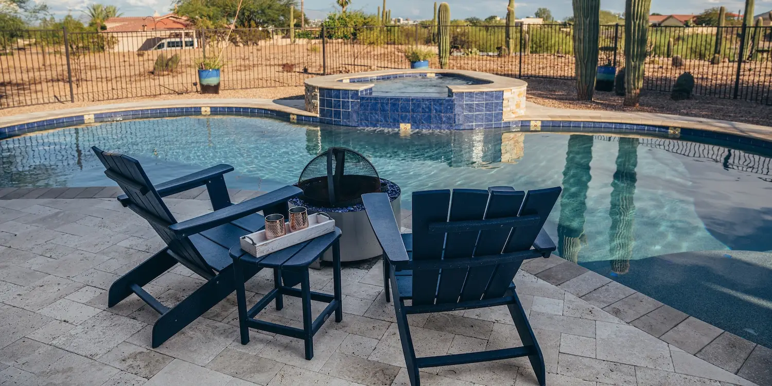 a fire pit with beach chairs near pool with tub style to enjoy pool in cold weather